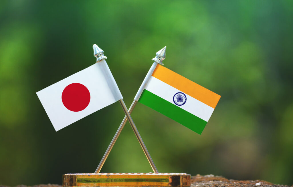 india,and,japan,small,flag,with,blur,green,background